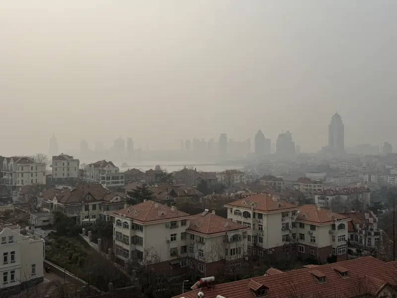 雾中红瓦老城与远处城市天际线
